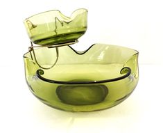 a green glass bowl sitting on top of a white table