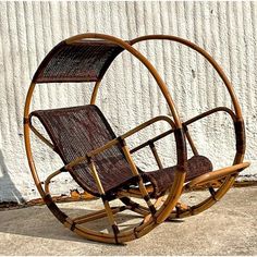 a wooden rocking chair sitting in front of a white wall