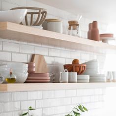 the shelves are full of dishes and cups on them, along with other kitchen items