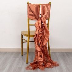 a chair with a ruffled cloth draped over the back of it in front of a white wall