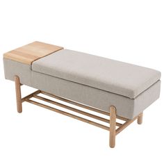 a small bench with a wooden shelf on it's side and a light gray fabric upholstered seat