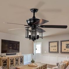 a living room with a ceiling fan and pictures on the wall