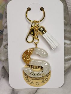 a keychain with a tassel hanging from it's side on top of a card