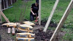 a woman is working in the garden with her tools and some boxes on the ground