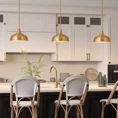 three chairs sitting in front of a kitchen counter with gold lights hanging above the island