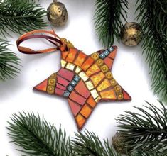 a stained glass star ornament hanging from a christmas tree