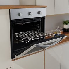 an oven with the door open on a kitchen counter