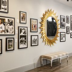 a room filled with pictures and a mirror on the wall next to a white bench