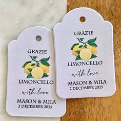 two tags with lemons on them are sitting on a table next to each other