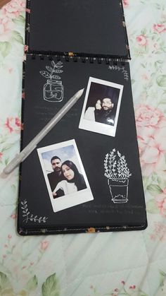 an open notebook with two photos and a pen on top of it next to flowers