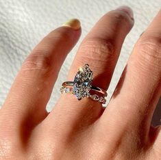 a woman's hand with a ring on it and a diamond in the middle