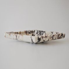 a white and black marble boat sitting on top of a table