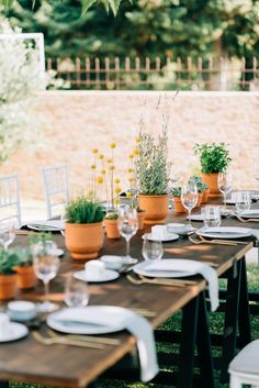 an outdoor table set with plates and place settings