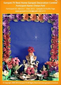 an elephant statue sitting in front of a blue backdrop with flowers and other decorations around it