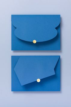 two blue envelopes with gold buttons on the front and back, one is empty