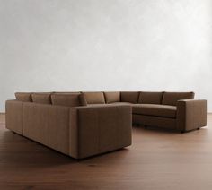 a brown couch sitting on top of a hard wood floor next to a white wall