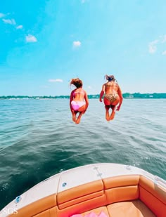 two people jumping into the water from a boat