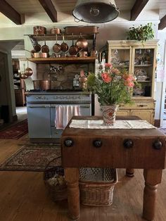 a kitchen with an island in the middle of it and pots on the shelves above