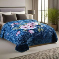 a bedroom with a bed covered in blue and pink flowers