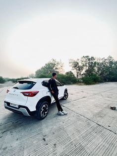 a man standing next to a white car