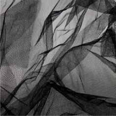 black and white photograph of sheer fabric with wavy lines on the bottom half of it