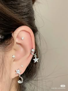 a woman wearing ear piercings with stars and moon designs