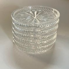 a stack of clear glass dishes sitting on top of a white countertop next to each other