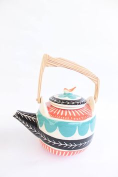 a tea pot with a wooden handle is shown on a white background, it appears to be made from ceramic