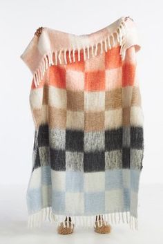 an orange, black and white checkered blanket with fringes