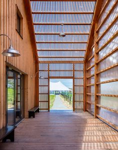 the inside of a wooden building with lots of windows and wood slats on the walls