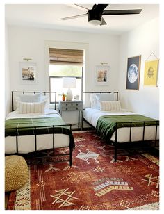 two beds in a room with a rug on the floor