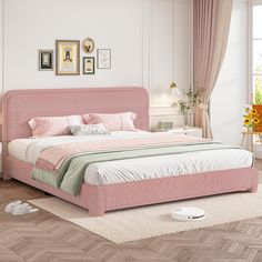 a bedroom with pink bedding and pictures on the wall, carpeted flooring