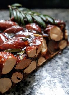 some kind of food that is on top of a stone table with leaves and sauce