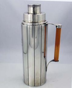 a stainless steel coffee pot with wooden handle