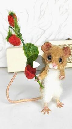 a tiny mouse holding a flower in it's hand