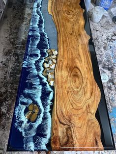 a table that has been made with wood and glass on top of the table is an ocean scene