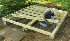 a man working on a wooden structure in the woods