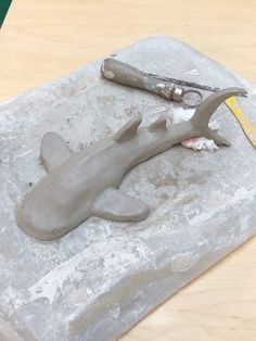 a sculpture of a shark with a pair of scissors on it