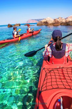 two people in kayaks paddling through clear water