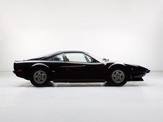 a black sports car parked in a white room