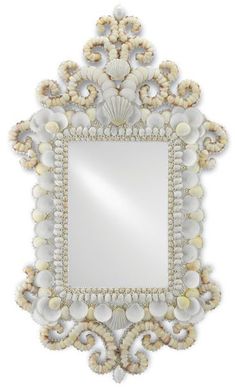 a mirror that has shells on it and is hanging in front of a white wall