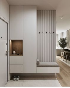 a room with white walls and wooden flooring next to a bench in front of a window