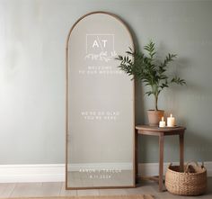 a mirror sitting next to a table with a potted plant on top of it