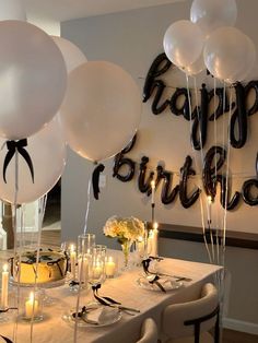 balloons and candles are on the table for a birthday party with black and white decorations