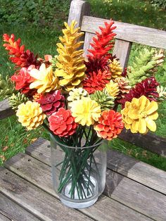 a vase filled with flowers sitting on top of a wooden bench