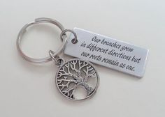 a keychain with a tree on it that says, our branches you in different directions but your parts remain as one