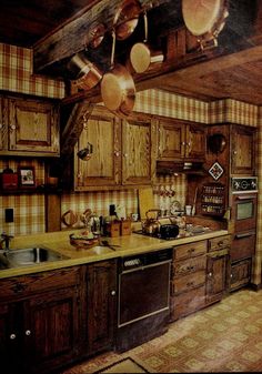 an old fashioned kitchen with wooden cabinets and hanging pots