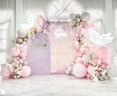 a pink and white backdrop with balloons, flowers and butterflies for a princess themed birthday party