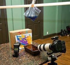 a camera and some other items on a table in front of a door with a painting