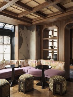 a living room filled with lots of furniture next to a large window and bookshelf